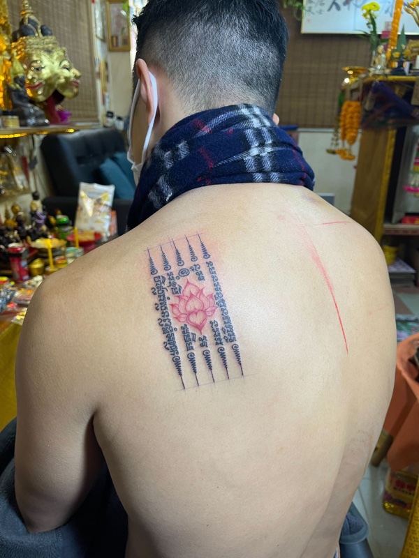Hah Taew with red lotus on shoulder